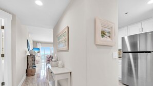 Een moderne keuken met witte kasten, een roestvrijstalen koelkast en een houten eettafel.