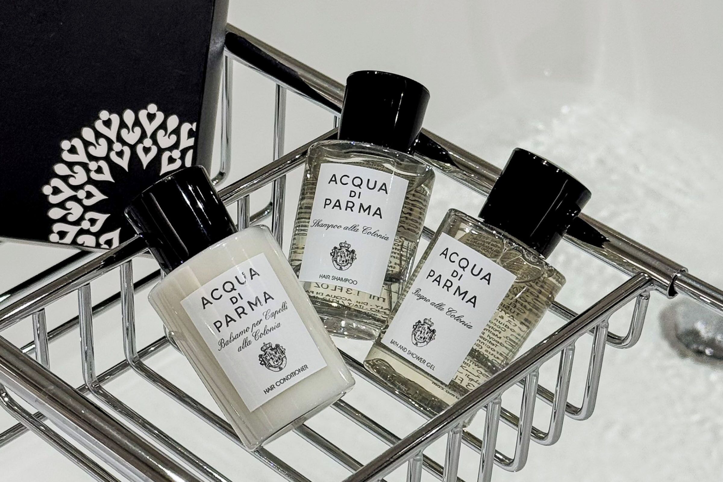 Un carrito de compras con tres botellas de productos para el cabello Acqua di Parma.