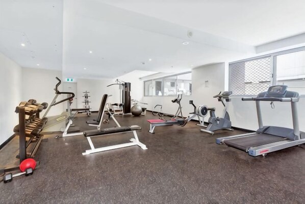 A gym with treadmills, elliptical machines, and weight equipment. - A Stylish Apt, City Views Next To Darling Harbour (Sydney)