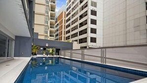 An indoor swimming pool with tiled walls and a metal railing. - A Stylish Apt, City Views Next To Darling Harbour (Sydney)