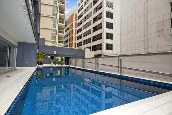 An indoor swimming pool with tiled walls and a metal railing. - A Stylish Apt, City Views Next To Darling Harbour (Sydney)