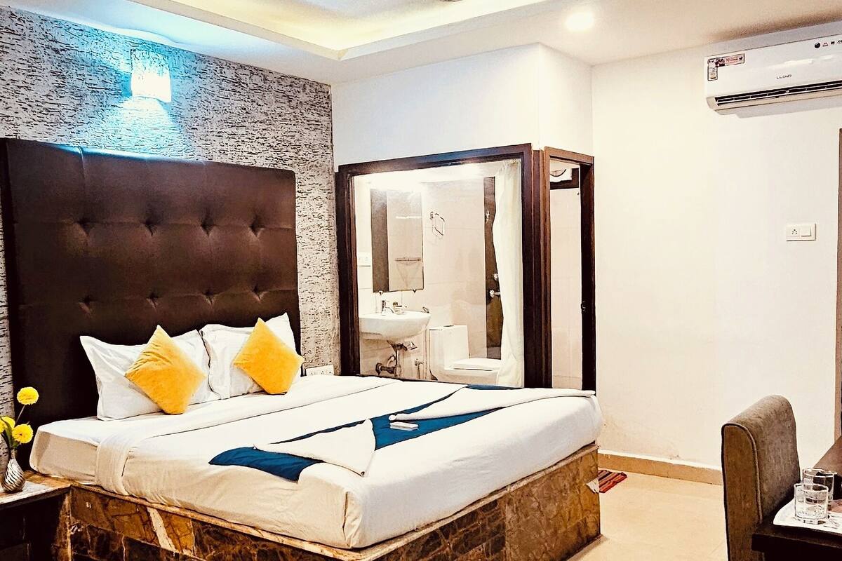 A modern bedroom with a marble headboard, a large bed, a desk, and a chair.