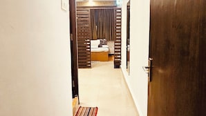 A hallway with a wooden door labeled '206', a tiled floor, and a striped rug. - Candolim Sands (Candolim)