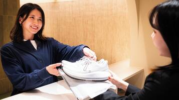 Eine Person hält einen Schuh über einem Tisch in einem Zimmer mit einer Holzwand und einer weißen Theke.