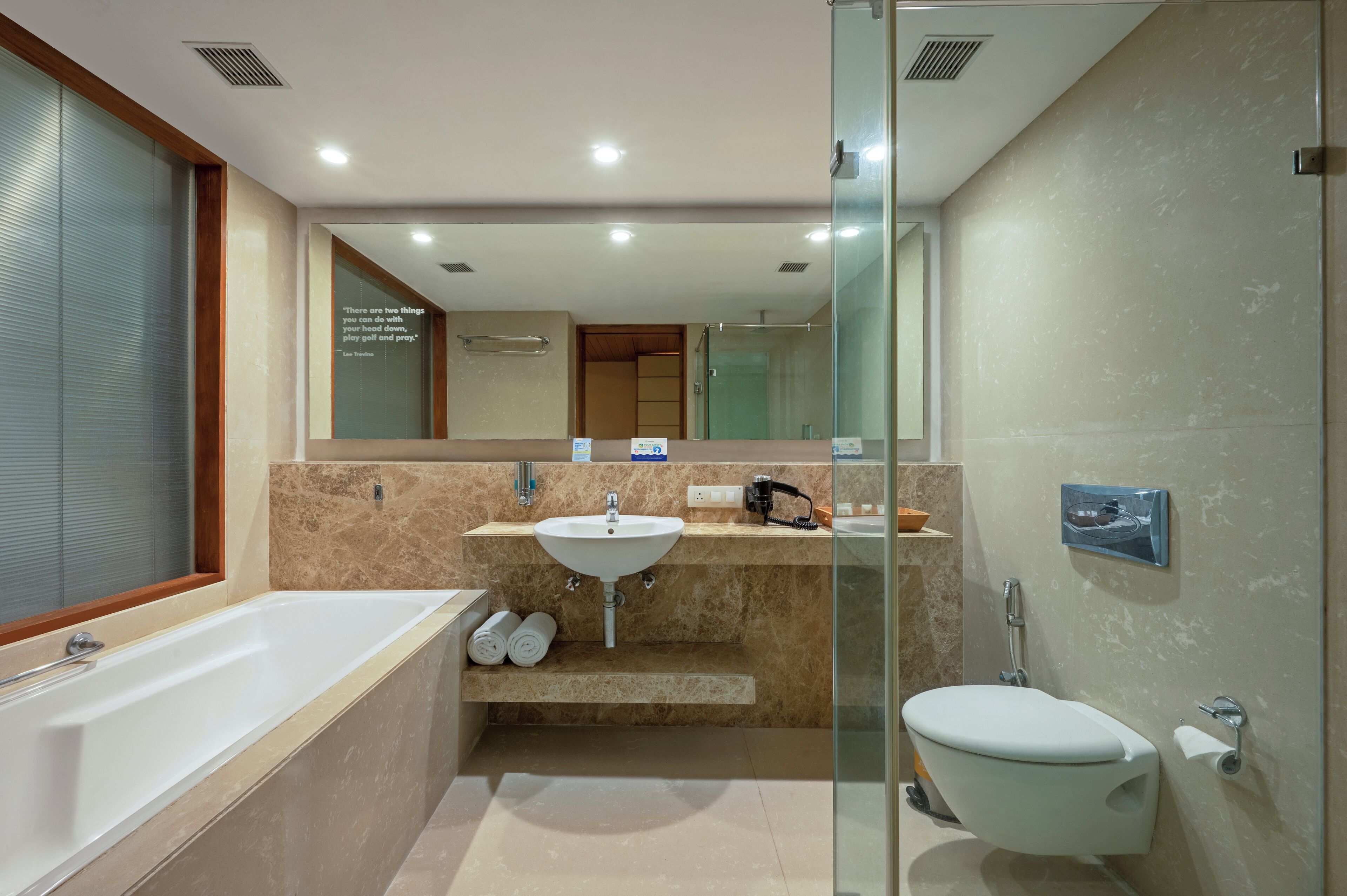 A modern bathroom with a bathtub, sink, and toilet.