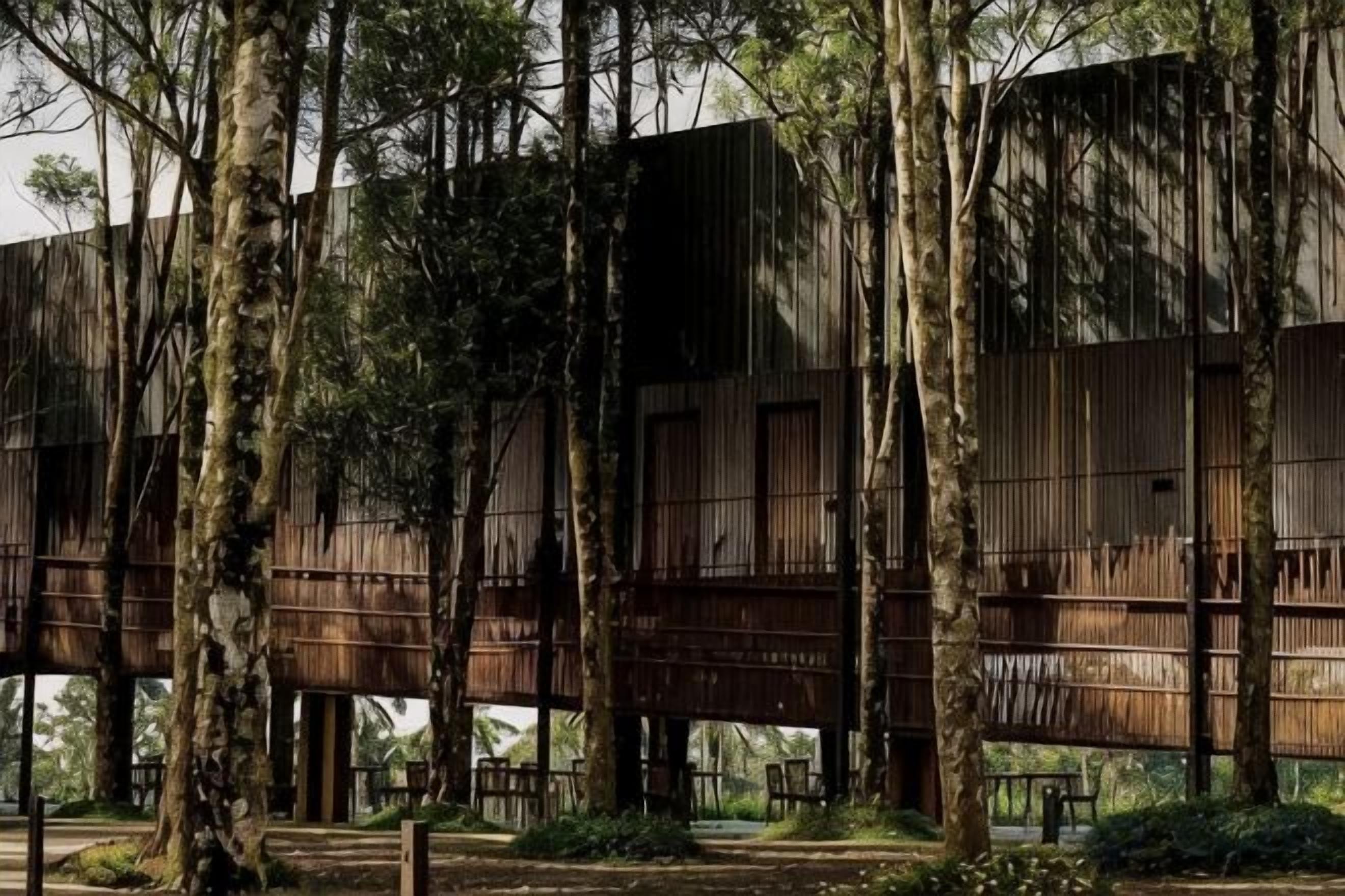 A modern building with a wooden exterior, surrounded by trees.