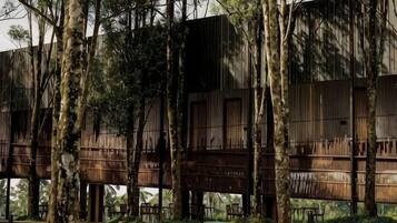 A modern building with a wooden exterior, surrounded by trees.