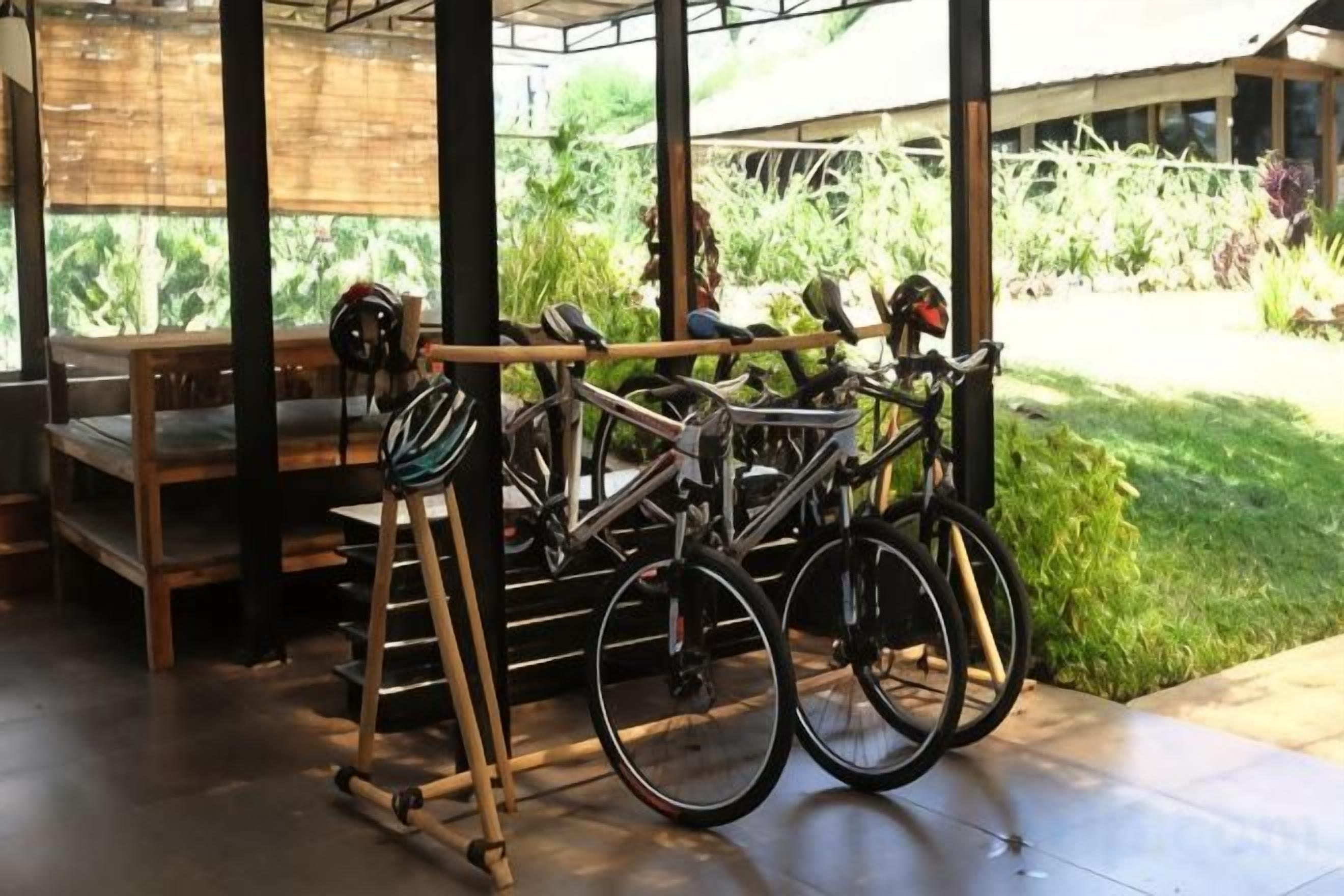 A bicycle rack with two bicycles and a helmet.