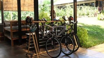 A bicycle rack with two bicycles and a helmet.