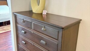 A wooden dresser with drawers and a decorative ring on top. - Samsen Suites (Bangkok)