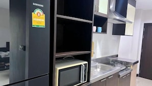 A modern kitchen with a Samsung refrigerator, a microwave, and a stainless steel sink. - Tongyang House Serviced Apartment (Bangkok)