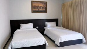 A hotel room with two single beds, a painting on the wall, and a large window with curtains. - Tongyang House Serviced Apartment (Bangkok)