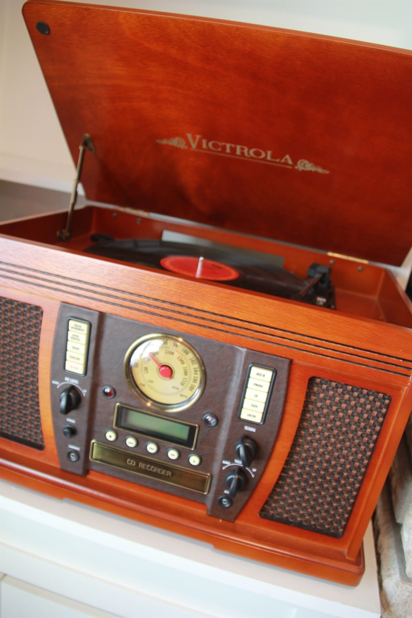 Un tocadiscos Victrola antiguo con detalles de madera y un reproductor de CD debajo.