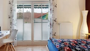 A bedroom with a bed, a desk, a chair, and a radiator. - Apartment 'Ketterer' with Terrace, Garden and Wi-Fi (Hüfingen)