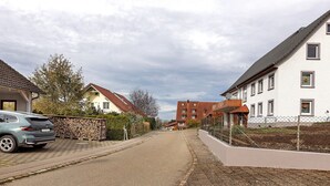 A residential street with houses, a parked car, and a paved road. - Apartment 'Ketterer' with Terrace, Garden and Wi-Fi (Hüfingen)