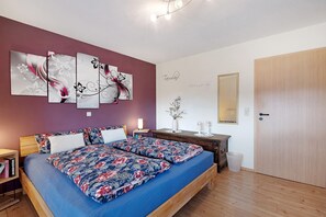 A bedroom with a bed, a nightstand, a dresser, a mirror, and a door. - Apartment 'Ketterer' with Terrace, Garden and Wi-Fi (Hüfingen)
