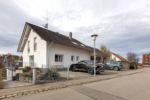 A residential house with a sloped roof, satellite dish, and a fenced yard. - Apartment 'Ketterer' with Terrace, Garden and Wi-Fi (Hüfingen)