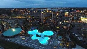 A multi-story hotel with a central courtyard featuring a pool.