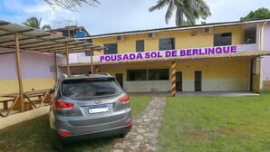 A building with a sign reading "POUSADA SOL DE BERLINQUE" and a parked car in front. - Pousada Sol de Berlinque (Vera Cruz)