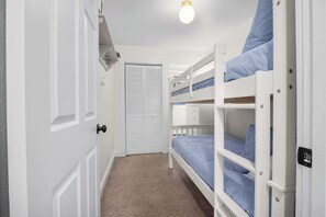 Una habitación pequeña y estrecha con literas y una puerta.