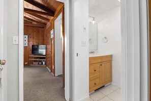 Een houten interieur met een televisie, houten kasten en een betegelde vloer.