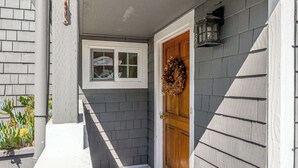 A house entrance with a wooden door, a window, and a wreath on the door. - Twin Lakes Surf Cabin - Sleeps Up To 12 (Santa Cruz)