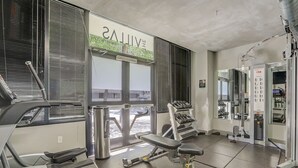 A gym with treadmills, weight machines, and dumbbells.