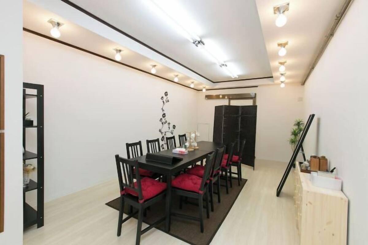 A dining area with a table, chairs, and a decorative wall piece.