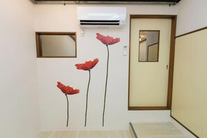 A hallway with a door, a mirror, and an air conditioning unit. - Nishioi House (Tokyo)