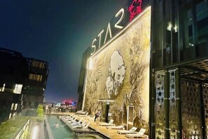 A hotel with a large outdoor pool area, lounge chairs, and a mural on the building facade. - Star Residence KLCC By Starlight (Kuala Lumpur)