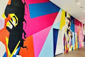 A hallway with vibrant, abstract wall art and a door on the right. - Star Residence KLCC By Starlight (Kuala Lumpur)
