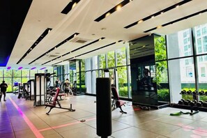 A gym with exercise equipment, large windows, and a view of the outdoors. - Star Residence KLCC By Starlight (Kuala Lumpur)