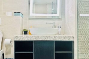 A bathroom with a white sink, a mirror above it, and a toilet to the left. - Star Residence KLCC By Starlight (Kuala Lumpur)