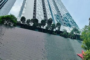 A high-rise building with a reflective glass facade and a patterned metallic structure at the base. - Star Residence KLCC By Starlight (Kuala Lumpur)