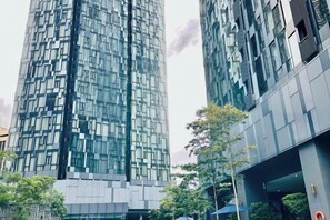 A modern high-rise building with a glass facade, surrounded by other buildings and greenery. - Star Residence KLCC By Starlight (Kuala Lumpur)