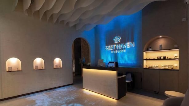 A reception area with a modern design, featuring a reception desk, a wall-mounted display, and a seating area. - Hotel Brynton at Cameron Centrum Mall (Brinchang)