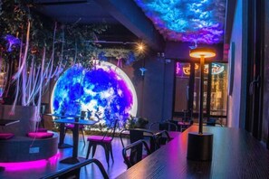 A restaurant with a large illuminated globe, modern furniture, and ambient lighting. - Hotel Brynton at Cameron Centrum Mall (Brinchang)