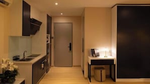 Een moderne keuken met een spoelbak, kastjes en een deur die naar een andere kamer leidt.