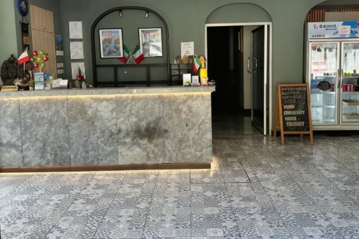 A reception area with a marble counter, framed pictures, and a refrigerator with a sign.