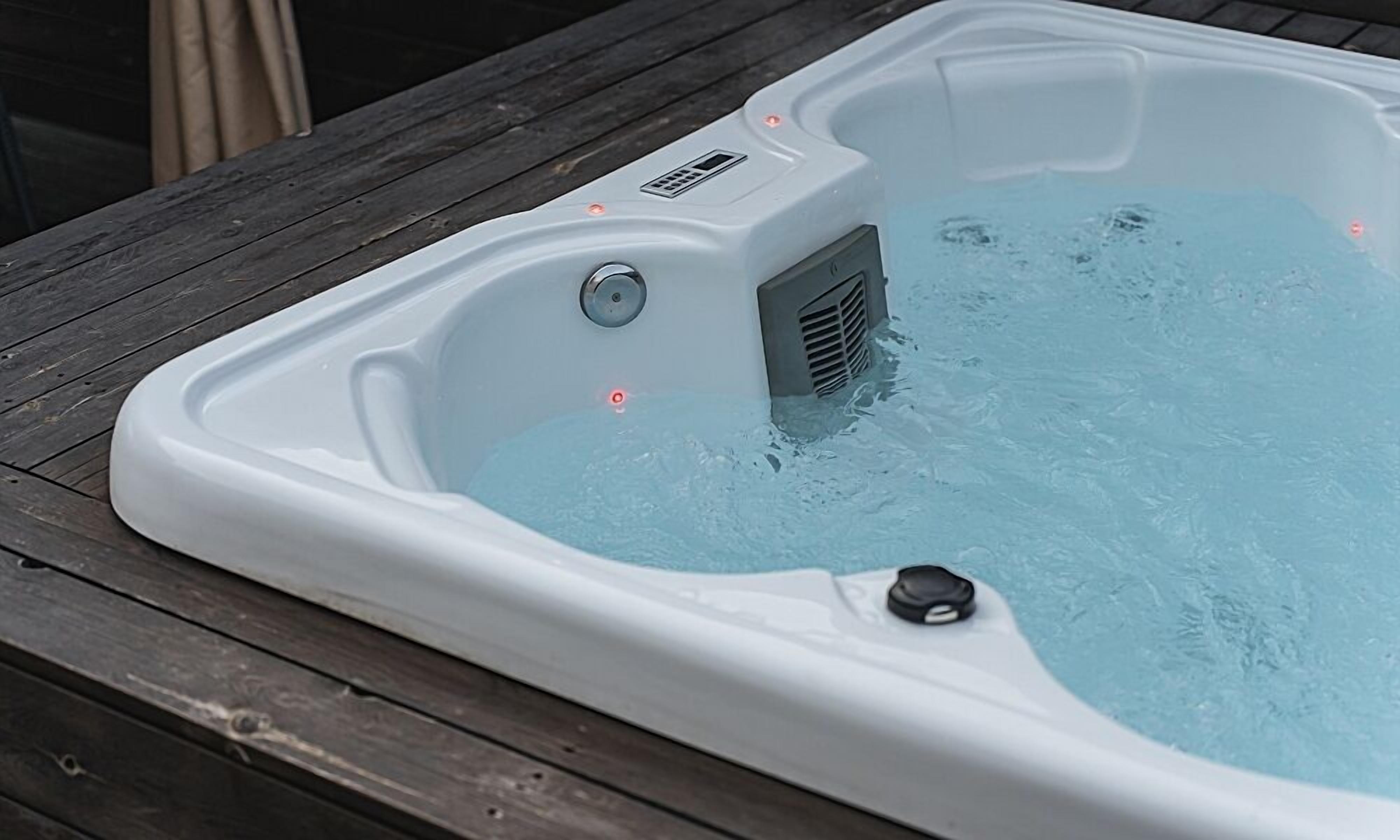 Un jacuzzi con panel de control y toma de corriente en una terraza de madera.