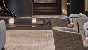 A modern lobby with a spiral staircase, seating area, and a large screen. - Shilla Monogram Xi'an (Xi'an)