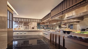 A modern kitchen with a long counter, stainless steel appliances, and a high ceiling. - Shilla Monogram Xi'an (Xi'an)