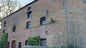 Un bâtiment en briques sur lequel on peut lire l’inscription : « The Carriage House ».