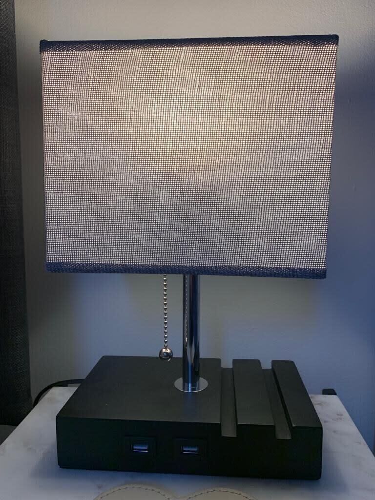 A modern desk lamp with a square base and a mesh shade.