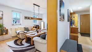 Een moderne woonkamer met een bank, salontafel en hanglamp.