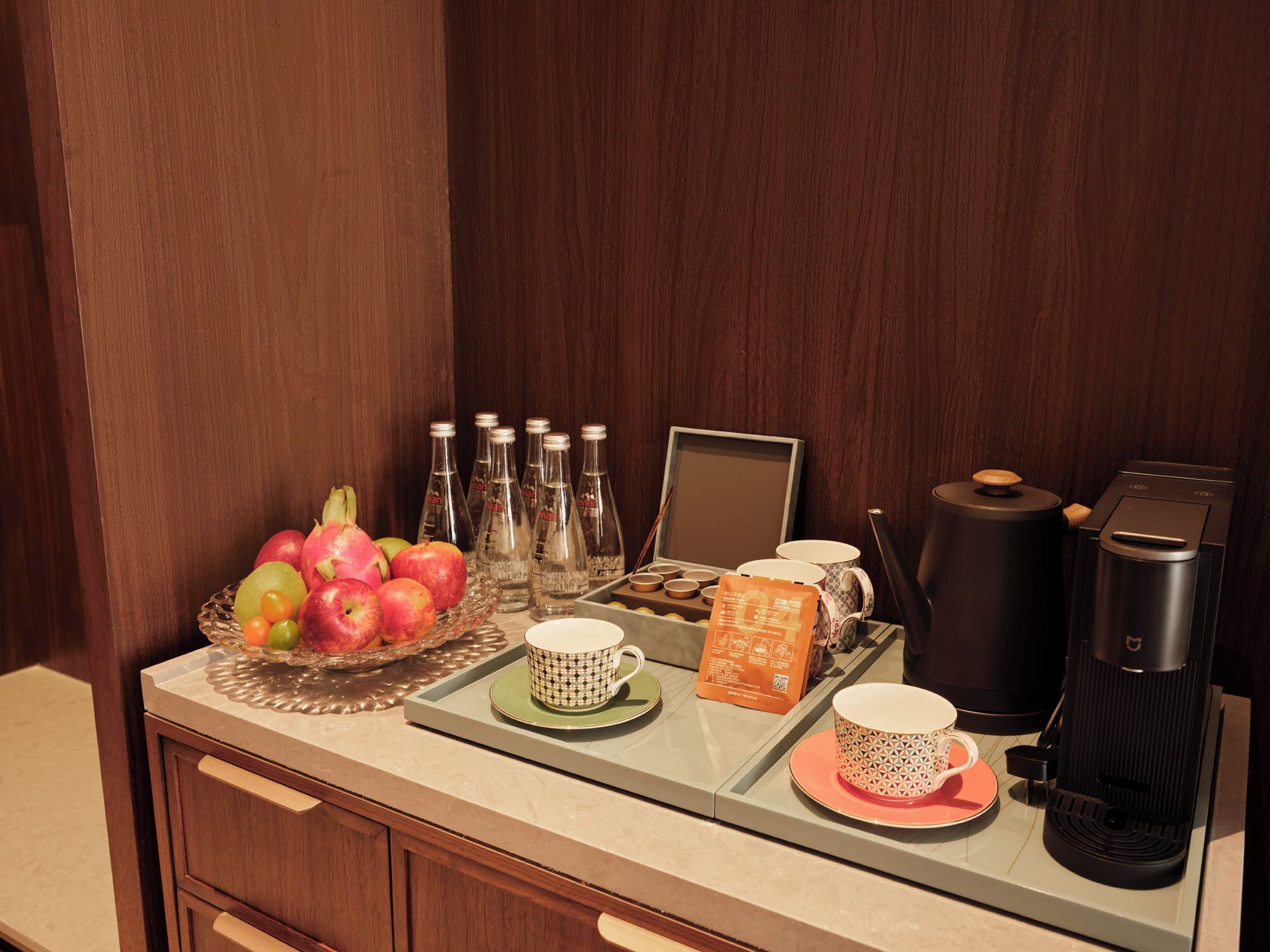 Una mesa de madera con frutas, café y té para el desayuno.
