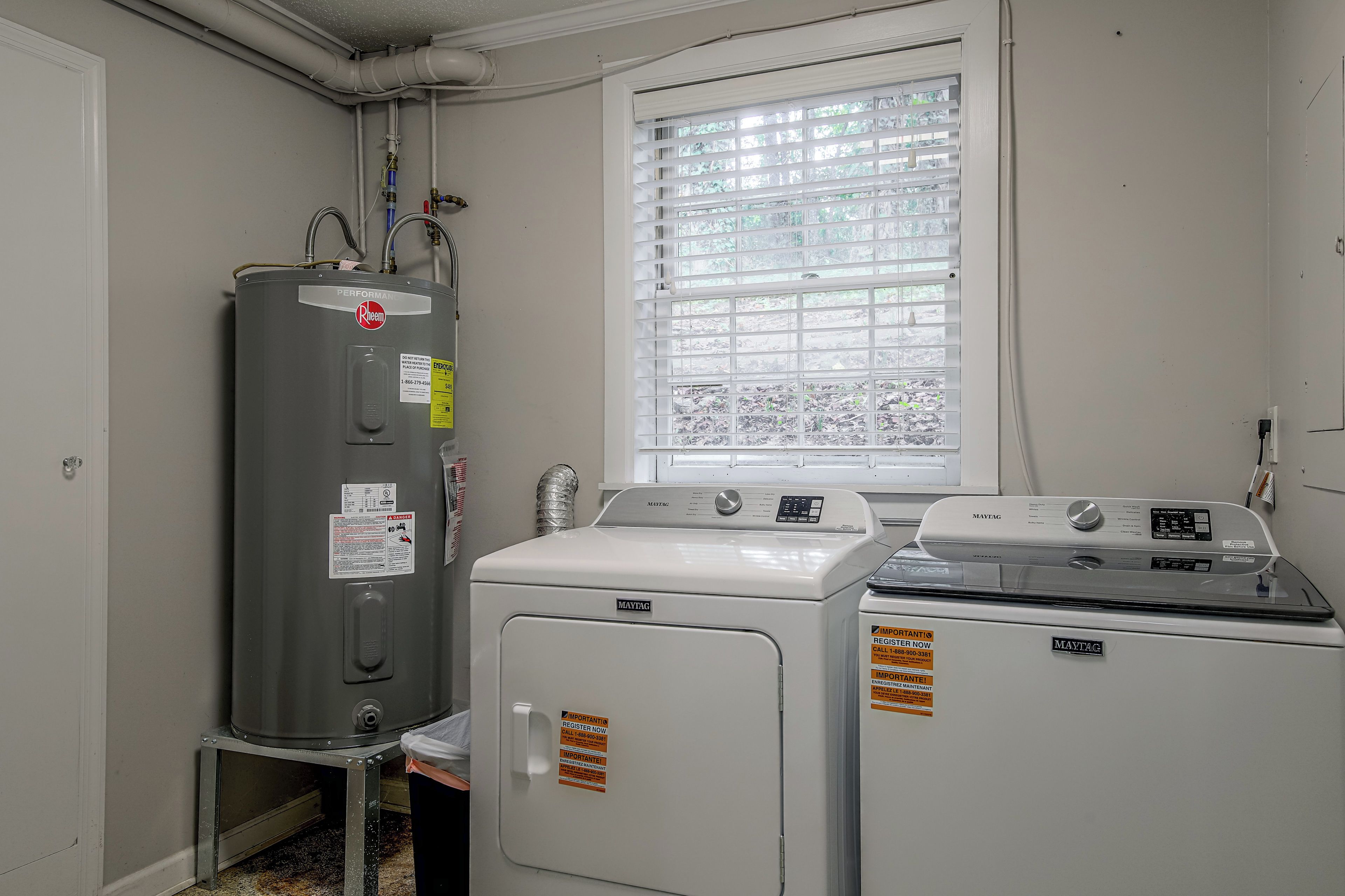 Een wasserette met een boiler, wasmachine en droger.