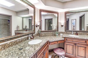 A bathroom with two sinks, marble countertops, wooden cabinets, and large mirrors. - Golf, Swim & Grill: Snowbird’s Escape in Sun Lakes (Sun Lakes)