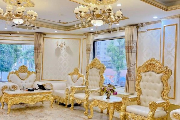 A luxurious room with ornate golden chairs, a chandelier, and large windows with curtains. - KIM A HOTEL (Bac Ninh)