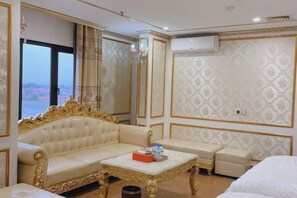 A hotel room with a large window, a sofa, a small table, and a bed. - KIM A HOTEL (Bac Ninh)